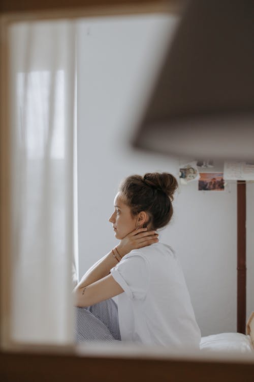 Mirror Reflection of Woman Sitting on a Bed