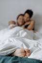 镜头特写一对夫妇躺在床上，重点突出他们放松的双脚