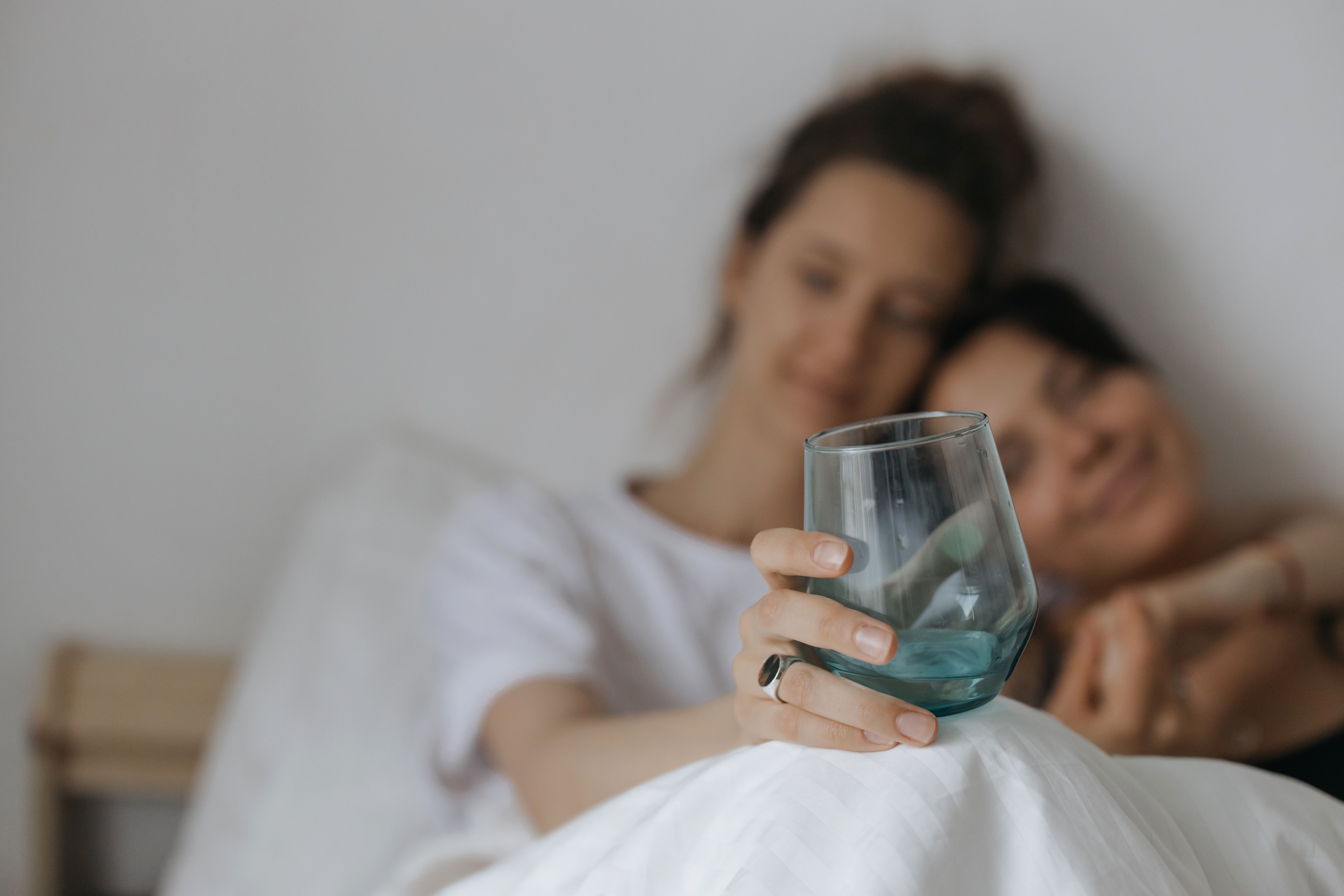 peaceful bedroom at night with a glass of water and natural supplement powder on a wooden nightstand, soft warm lighting from a bedside lamp