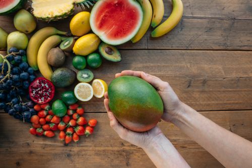 Free A variety of fresh fruits including mango, watermelon, and avocado on a wooden surface. Stock Photo