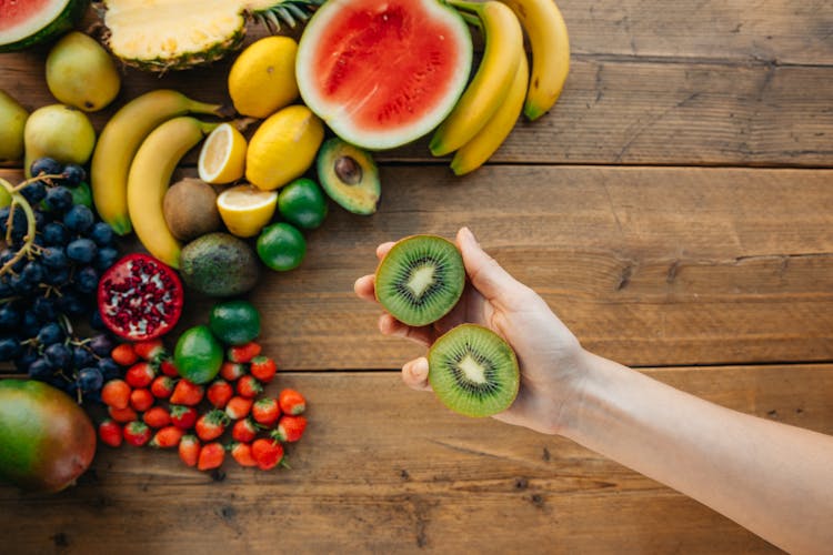 Sliced Kiwi Fruit On Person's Hand