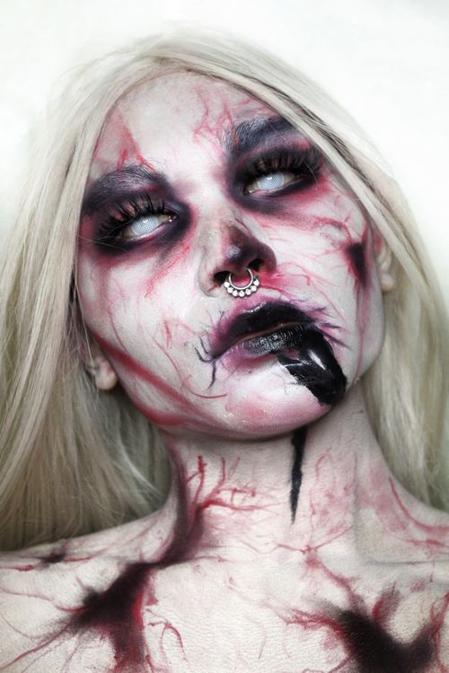 Free Eerie portrait of a woman with long gray hair and intricate spooky face makeup. Stock Photo