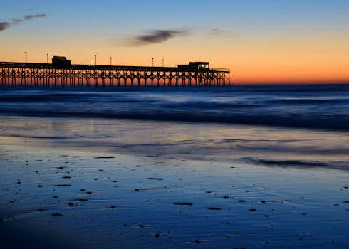Silhouette of Myrtle Beach pier against a vibrant sunset sky.