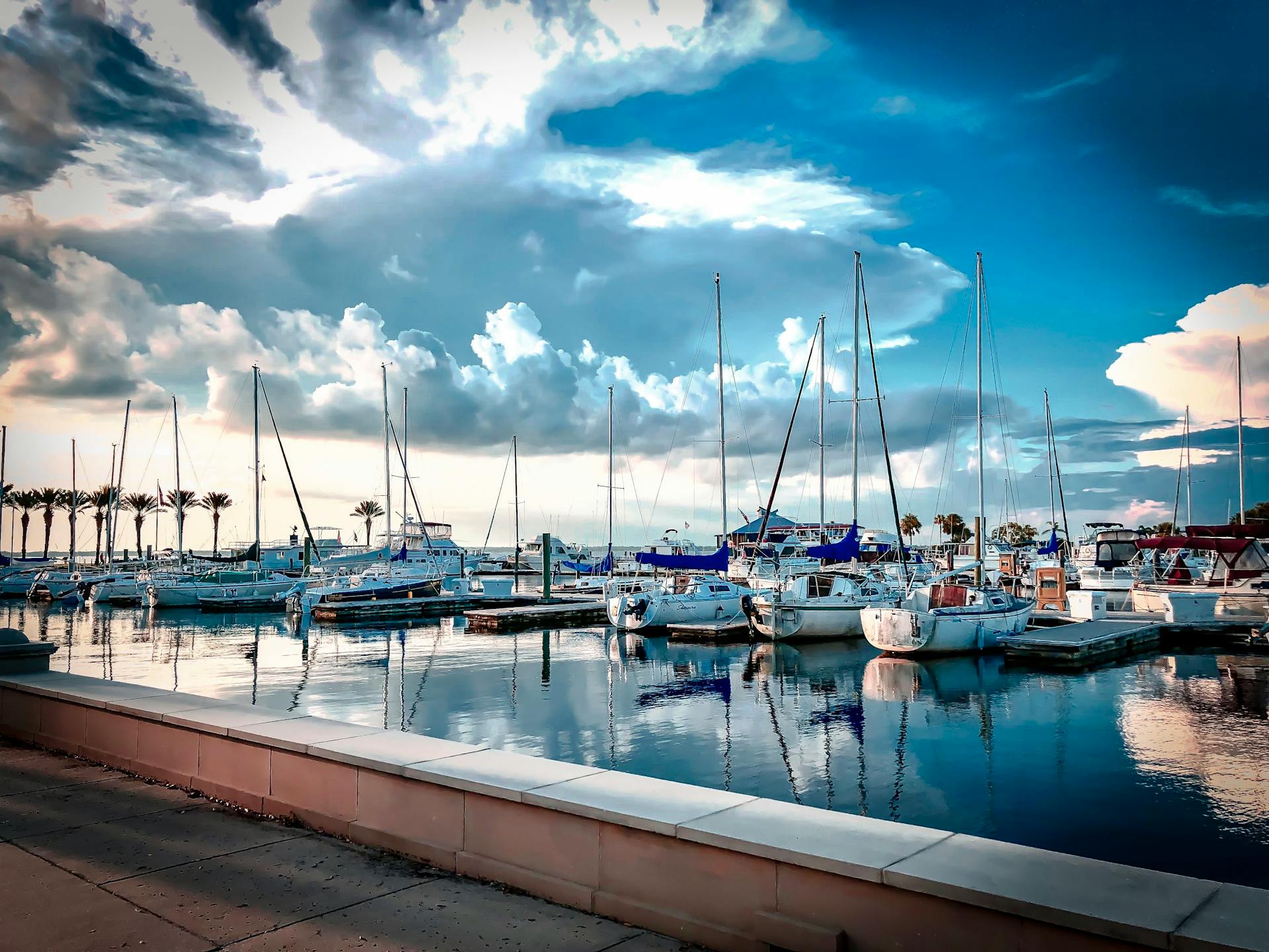 Scenic view of docked sailboats under dramatic clouds in Sanford marina, Florida.