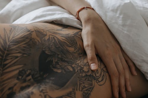 Человек с черной татуировкой на левой руке