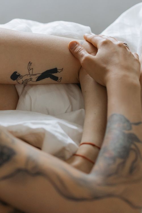Free A close-knit couple with tattoos in a gentle embrace, creating an intimate scene. Stock Photo