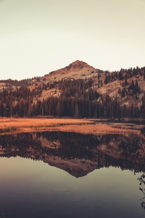 Free Serene landscape of a mountain and lake reflecting at sunset, capturing nature's calm beauty. Stock Photo