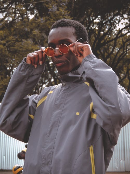 Man in Grey and Yellow Zip Up Jacket Wearing Sunglasses