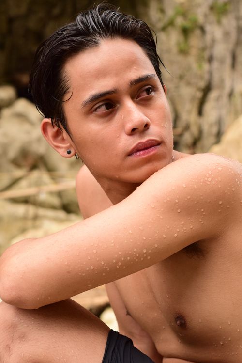 Free Portrait of a wet shirtless young man with short hair looking sideways, outdoors. Stock Photo