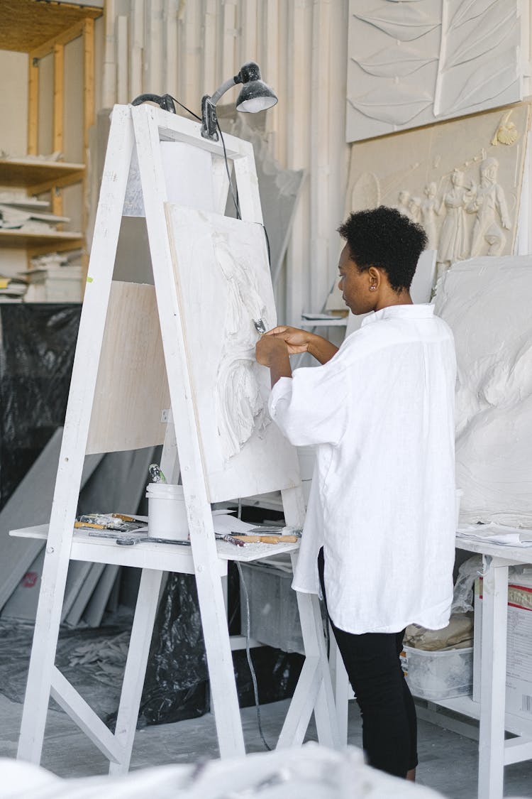 Artist Standing Beside An Easel Stand