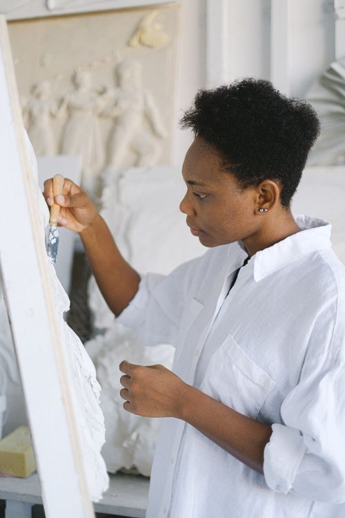 Free An artist works on a sculpture with precision and creativity in a light-filled studio. Stock Photo