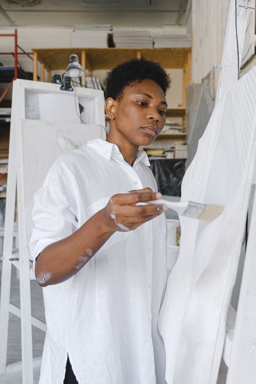 Free Artist in white shirt painting with concentration in a studio environment. Stock Photo