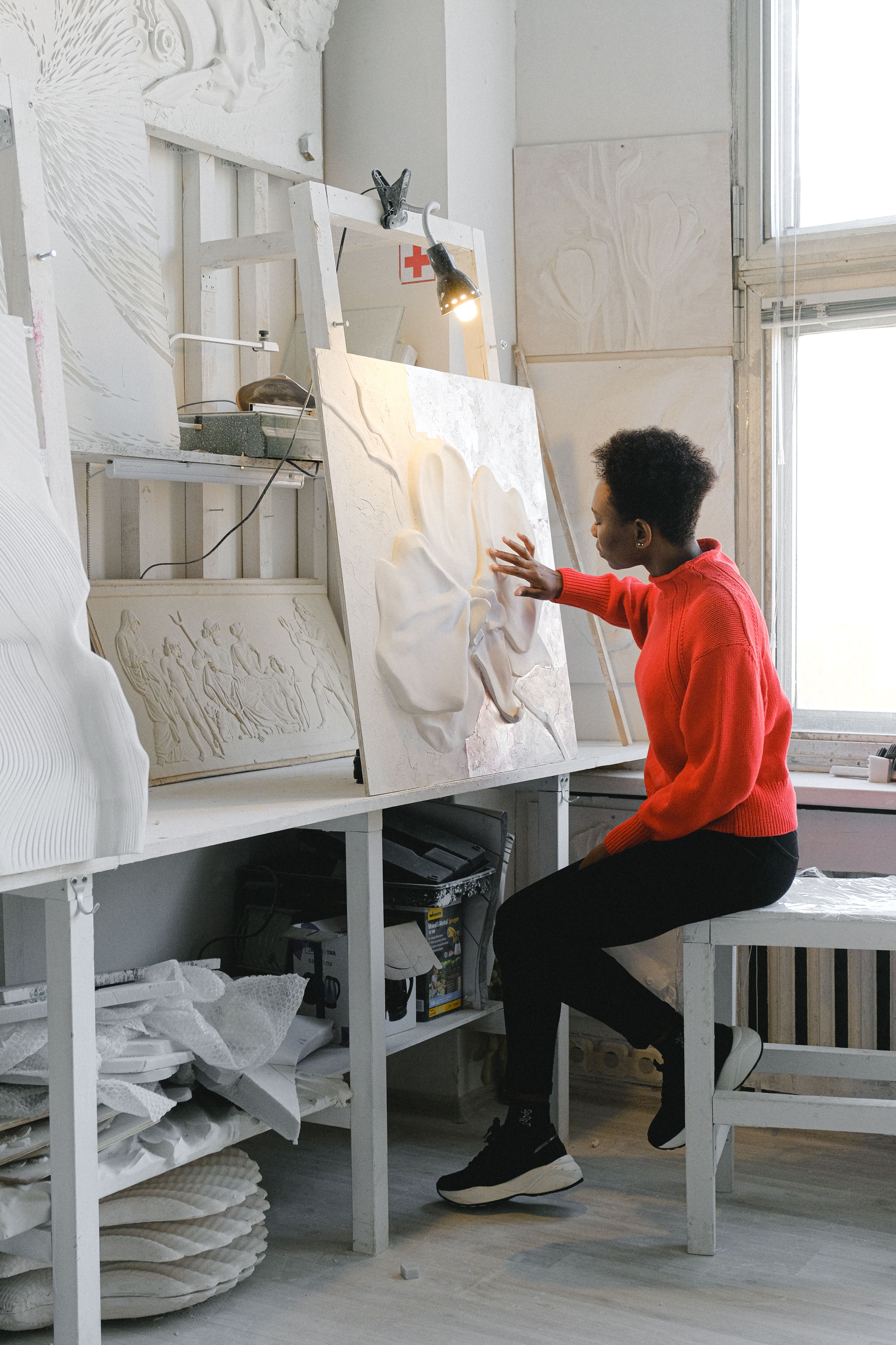 Black female artist working on a sculpture in a creative studio setting.