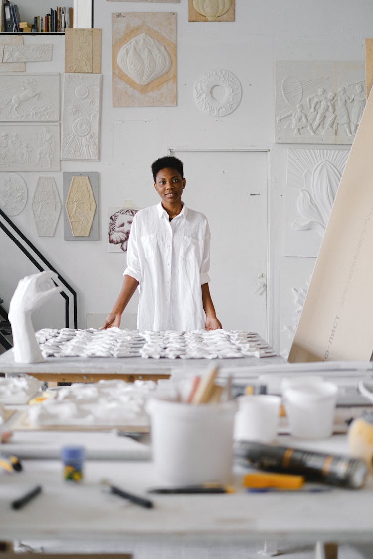 Person Standing Infront Of A Table With Ceramic Materials