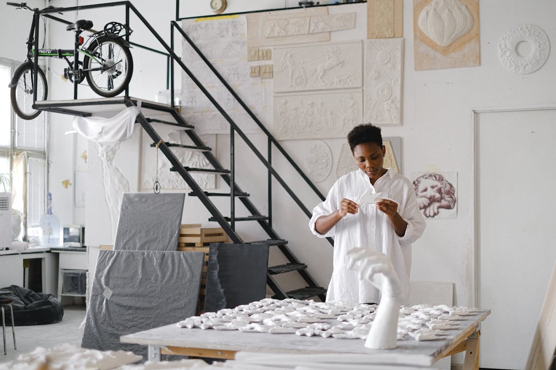 Person Standing Infront Of A Table With Ceramics