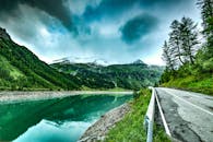 宁静的山地景观中，有波光粼粼的湖泊和蜿蜒的道路