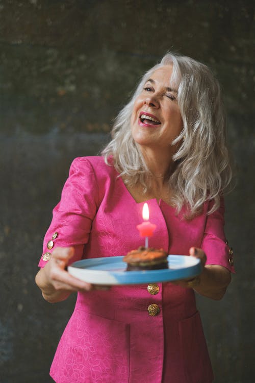 Free A Woman in Pink Dress Holding Round Tray with a Cake Stock Photo