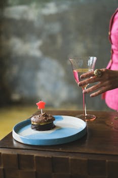 A stylish setup featuring a chocolate cake with a candle and a glass of wine, perfect for celebrating a birthday.