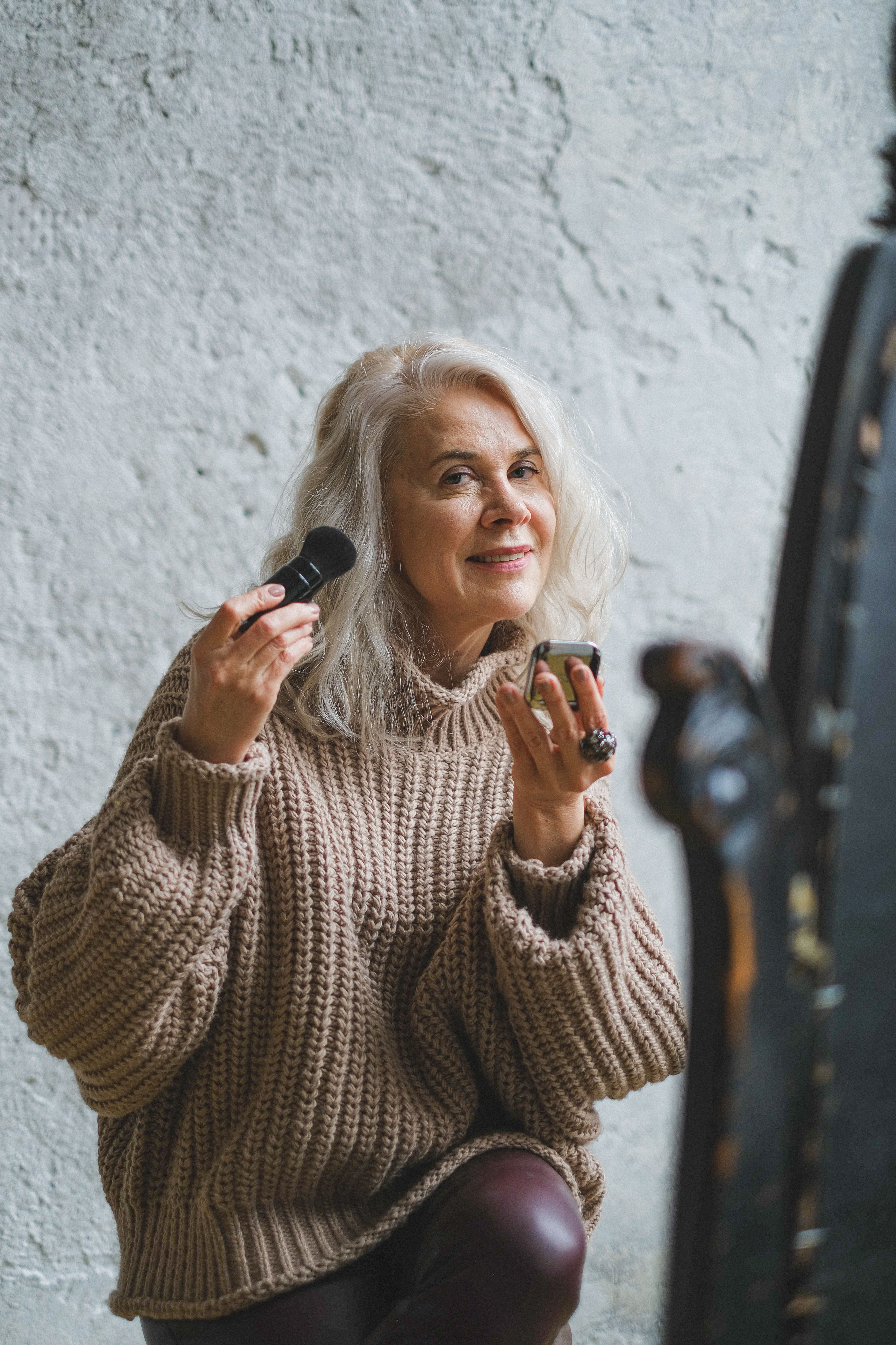 Elderly woman enjoying her beauty routine at home. Happiness and self-care in later life.