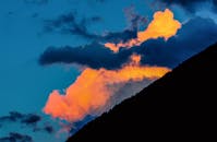 天空中，戏剧性的日落云照亮了山脉轮廓，呈现出一片充满活力的自然景观