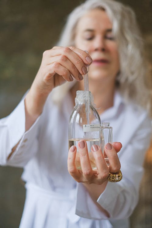 Selective Focus of Glass Bottle held by a Woman 