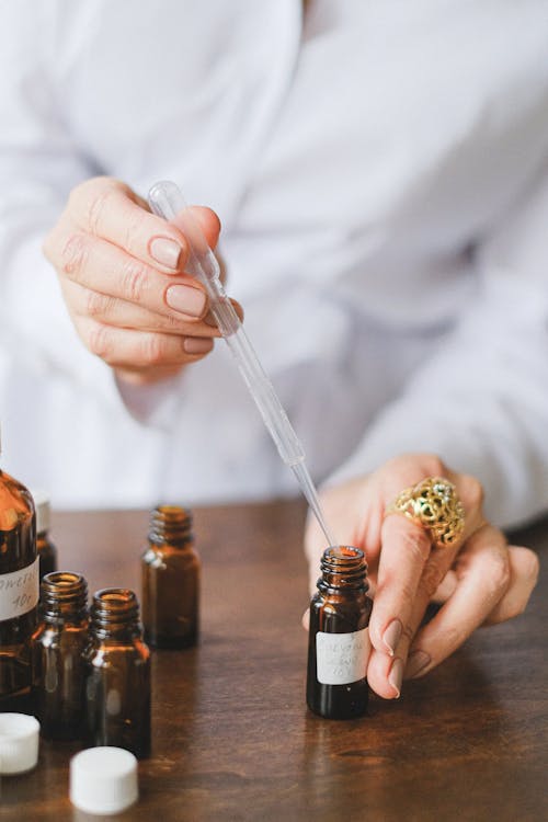 Selective Focus Photo of Dropper and Amber Bottles 