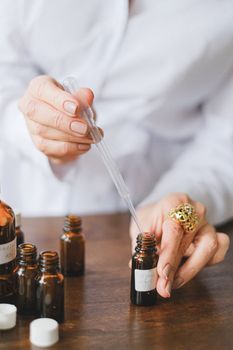 手部特写：用棕色玻璃瓶滴头装精油