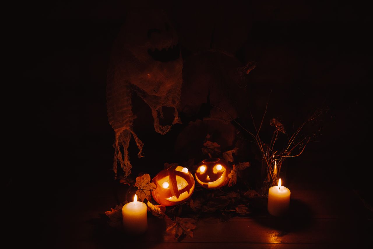 moody halloween display with glowing pumpkins and candles casting eeri