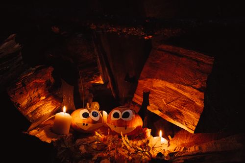 Free Charming jack-o'-lanterns with candles in a cozy autumn setting, perfect for Halloween atmosphere. Stock Photo