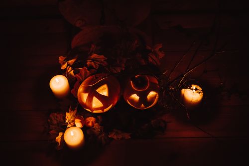 Free Festive Halloween scene of carved pumpkins and candles creating a spooky ambiance. Stock Photo