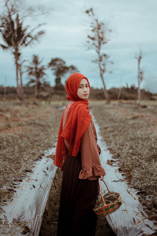 Woman in Red Hijab Holding a Basket 