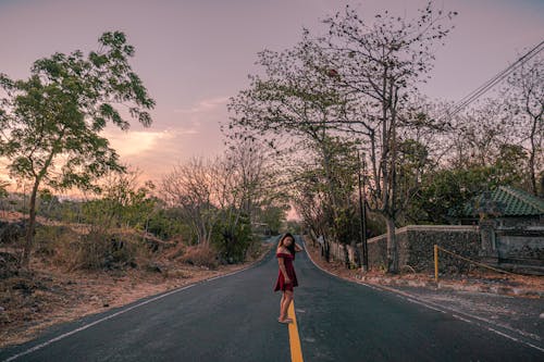 Woman in Red Dress Posing in the Middle of Road 