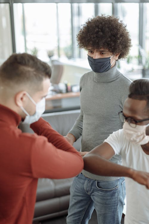 Men in Facemasks Doing Elbow Bump 