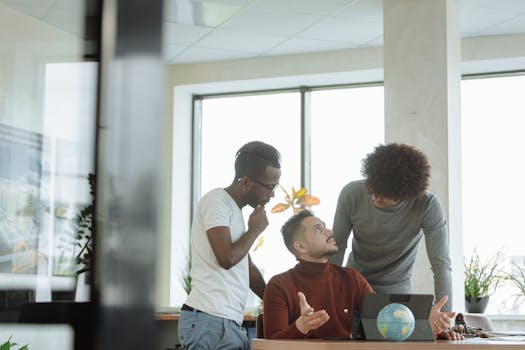 A diverse group of male colleagues discussing strategies in a modern office setting.