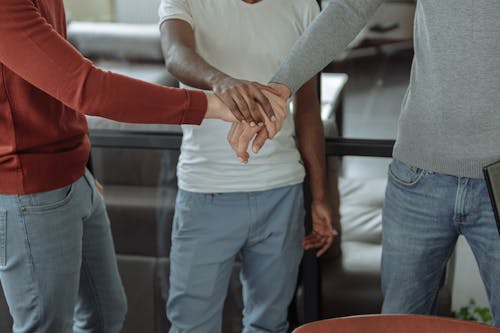 Men in Blue Jeans Hands Together While Standing