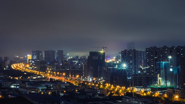 Captivating aerial view of a nighttime cityscape with illuminated buildings and streets.