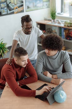 办公室里，三个男同事围着平板电脑讨论工作，强调多样性和团队合作