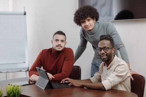Free Men in the Office Having a Meeting While Looking at Camera Stock Photo