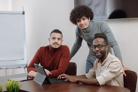 Three diverse team members working together on a project in a modern office environment.