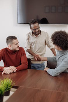 三名男子在专业场合握手，以期取得成功