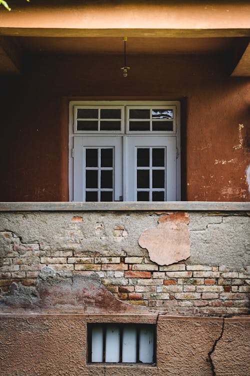 Facade of an Orange Building with a Broken Brick Wall 