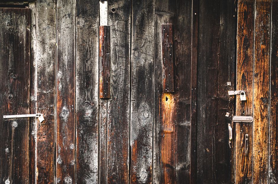 A close-up of an old, weathered wooden door showcasing rustic textures and natural wear.