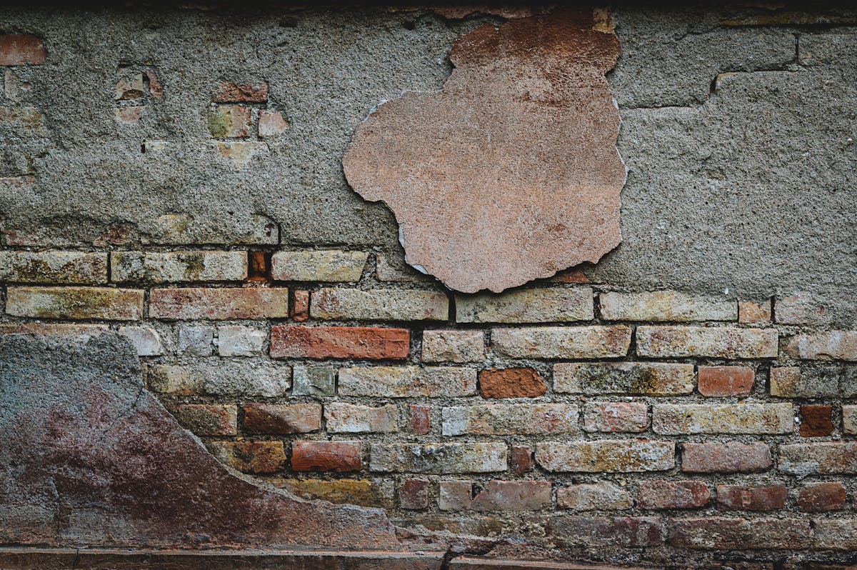 Cracked brick wall showing structural damage and building defects