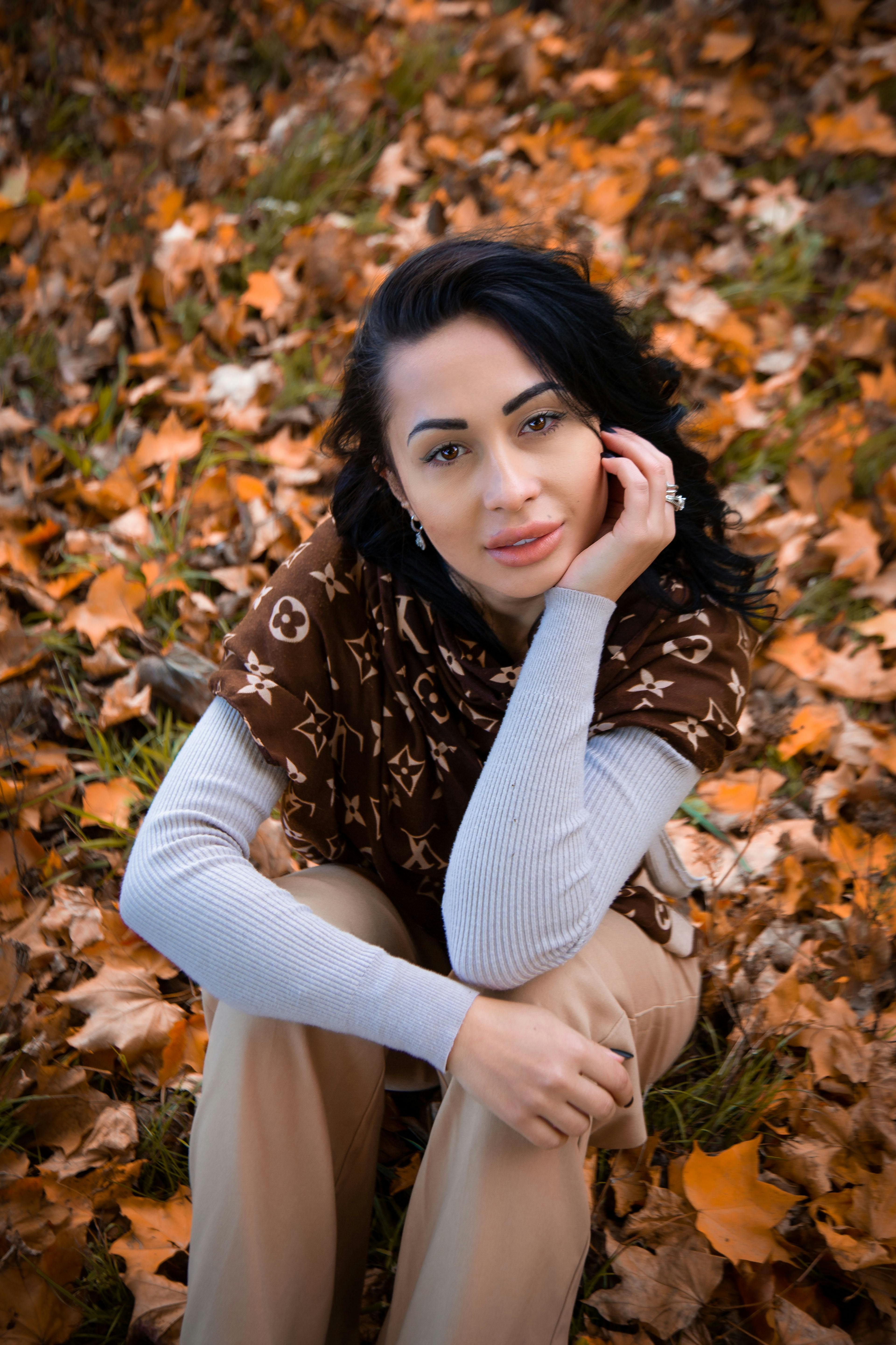 Woman with Louis Vuitton Scarf Sitting on Fallen Leaves · Free Stock Photo