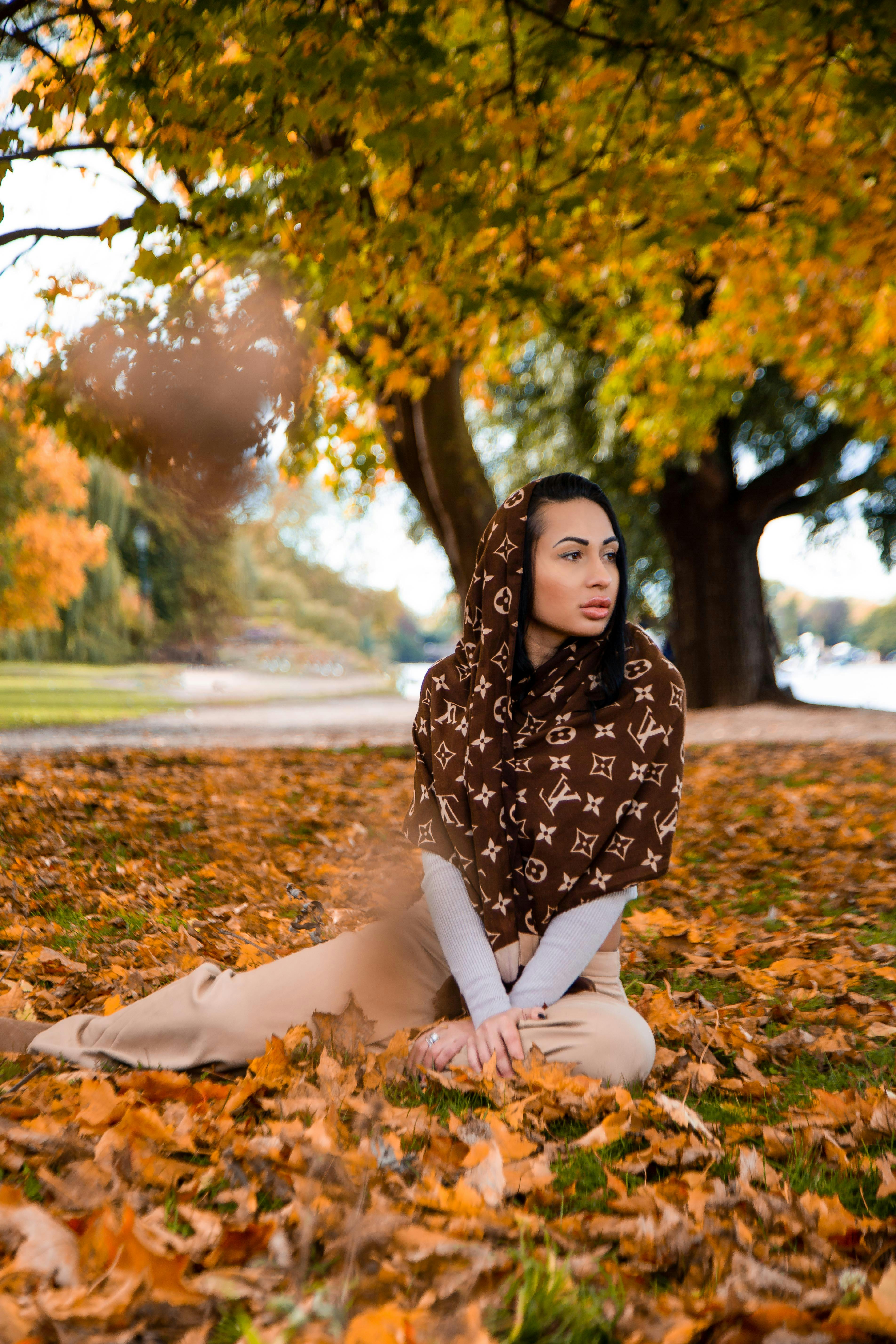 Woman with Louis Vuitton Scarf Sitting on Fallen Leaves · Free