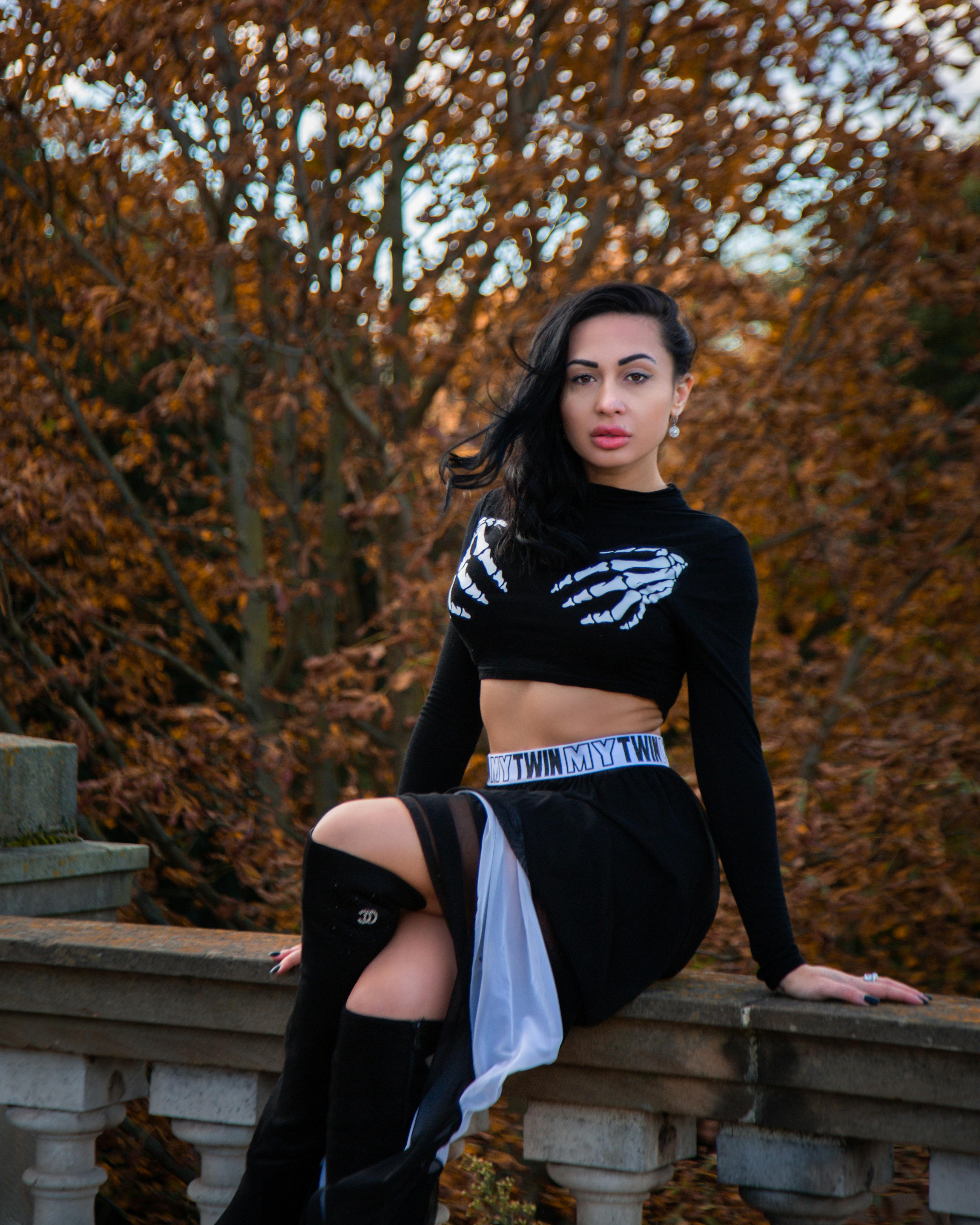 woman in branded outfit sitting on concrete fence