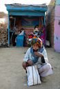 Elderly Man with Turban Squatting on Ground