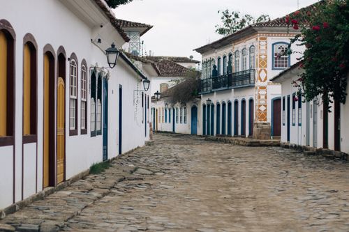 Free Picturesque cobblestone street lined with colorful colonial buildings in a quaint village. Stock Photo