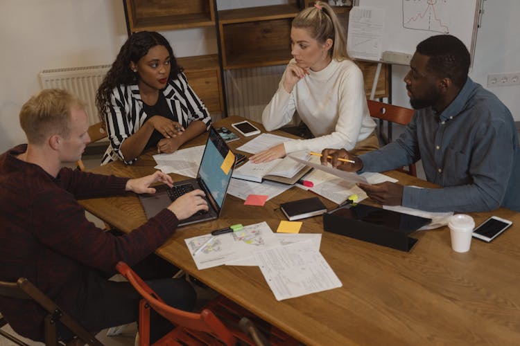 Interracial Group Of People Discussing At The Table