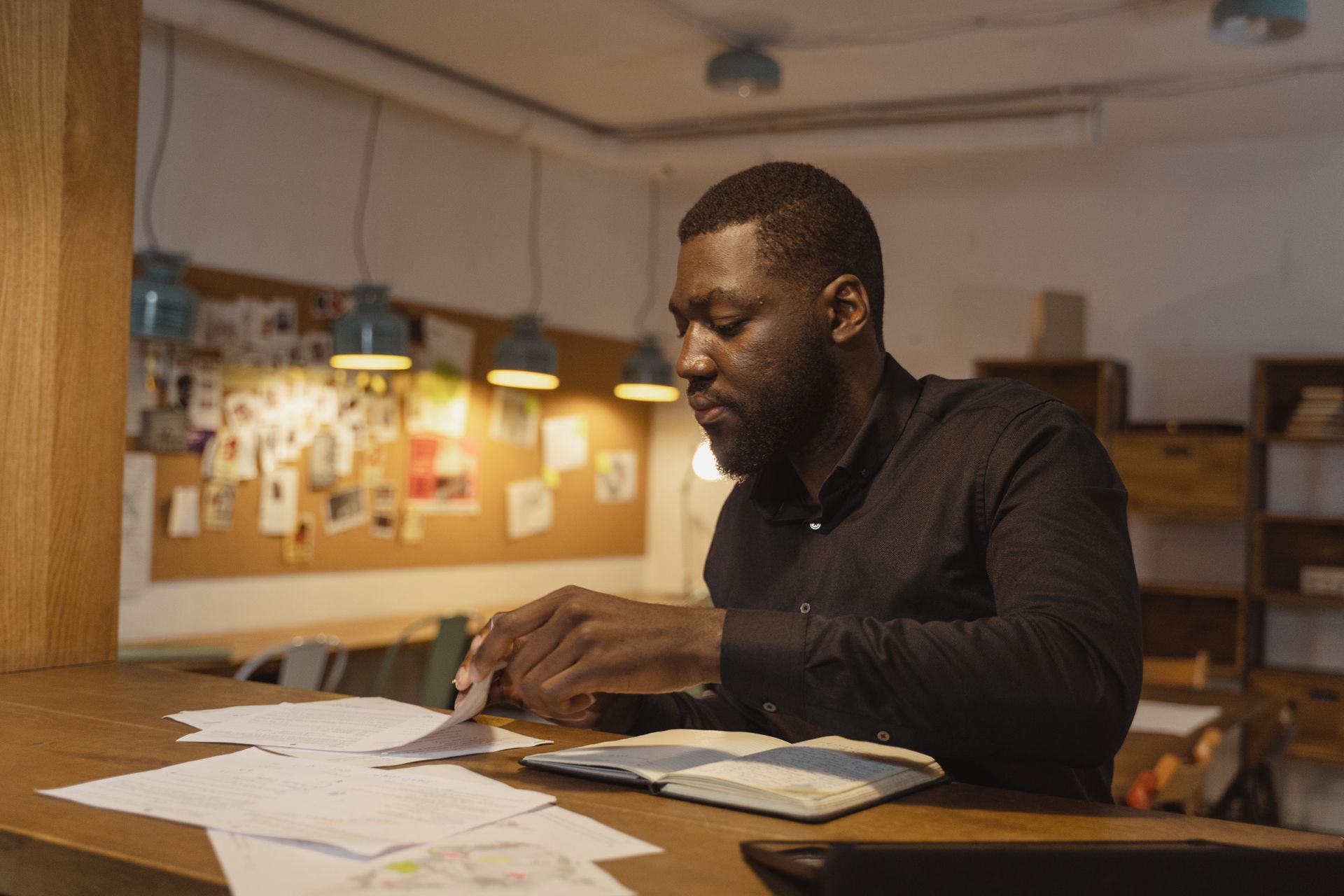A businessman working diligently with documents in a cozy indoor office setting.